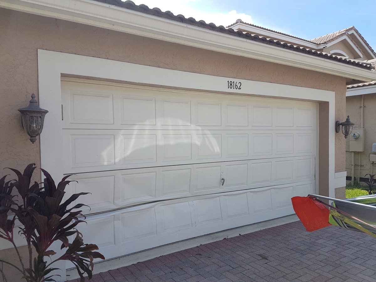 Damaged garage door before replacement in Florida